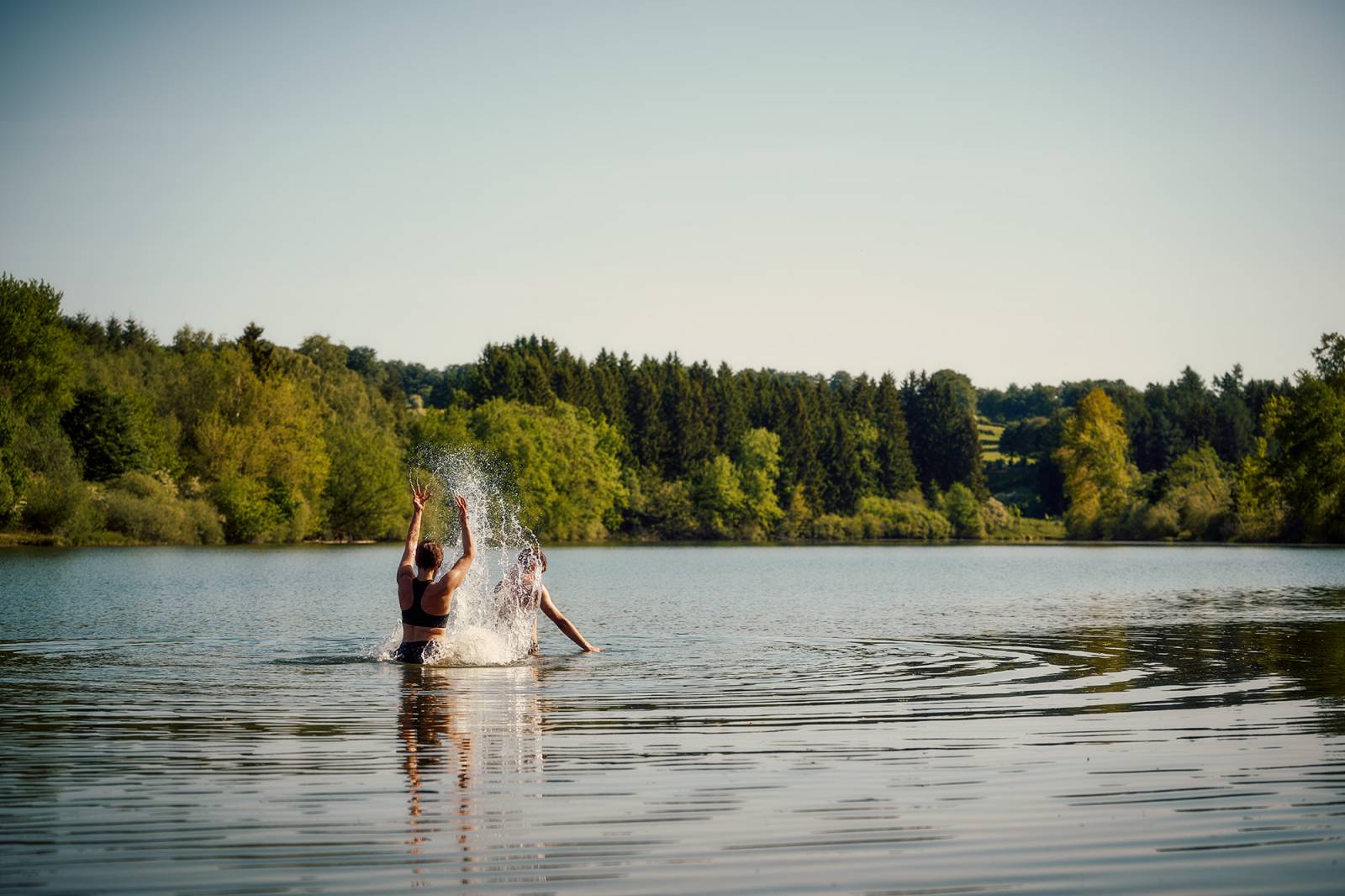 Personen spritzen mit Wasser im Bütgenbacher See