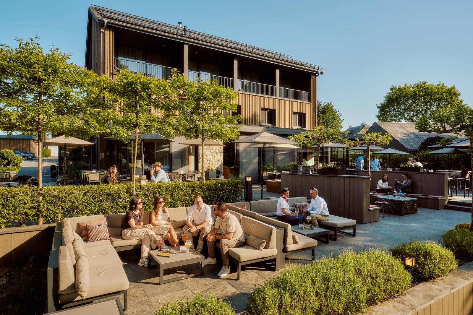 Personen entspannen auf der Terrasse des Naturhotel Bütgenbacher Hof im Sommer