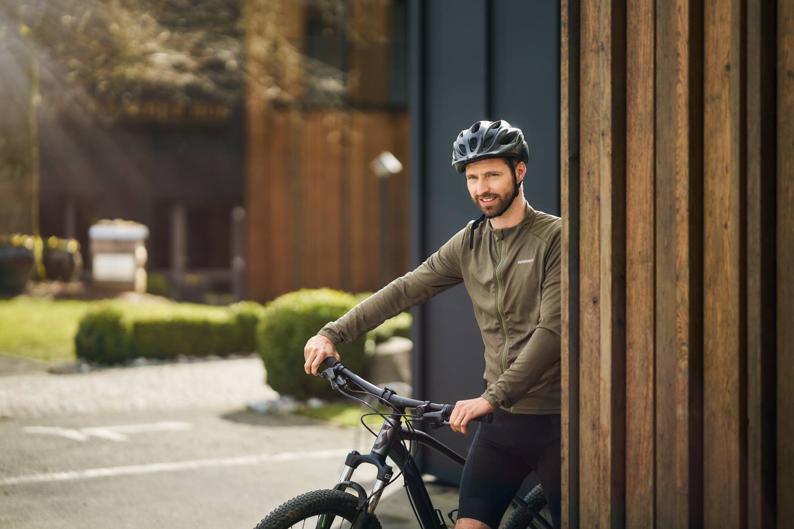 Mann schiebt ein Fahrrad über einen Hof