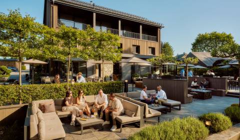 Personen entspannen auf der Terrasse des Naturhotel Bütgenbacher Hof im Sommer