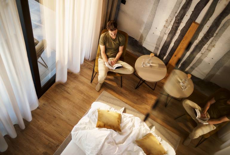 Mann entspannt im Zimmer im Lounge Bereich