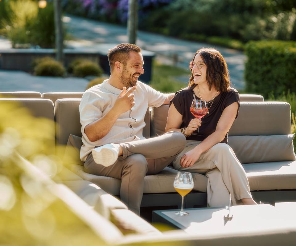 Mann und Frau trinken einen Aperitif auf der Terrasse des Naturhotel Bütgenbacher Hof