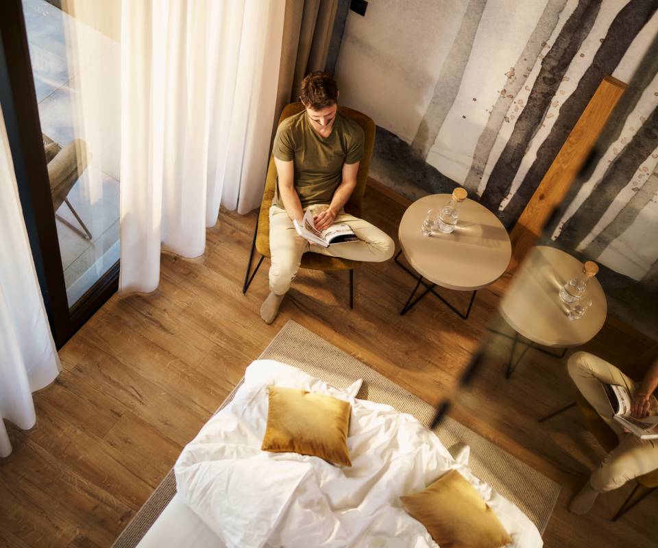 Mann entspannt im Zimmer im Lounge Bereich